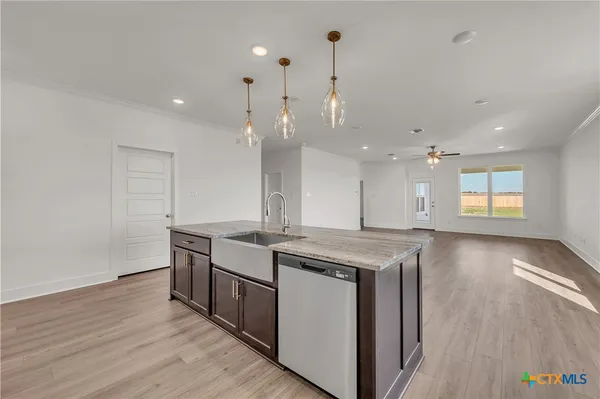 a kitchen with stainless steel appliances granite countertop a sink a stove and a wooden floors