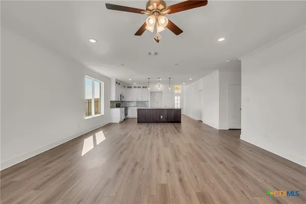 a view of empty room with wooden floor and window