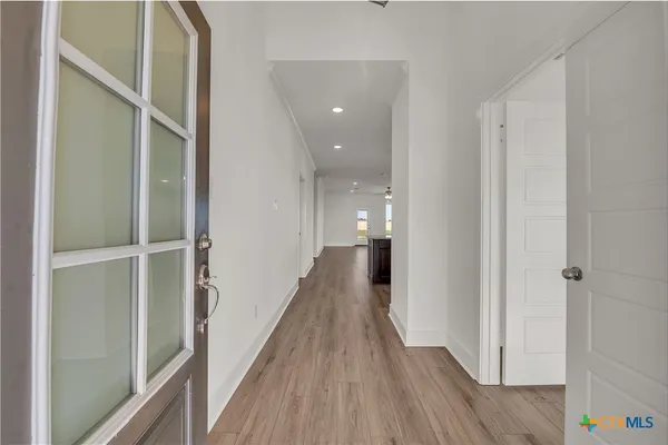 a view of a hallway with wooden floor and staircase