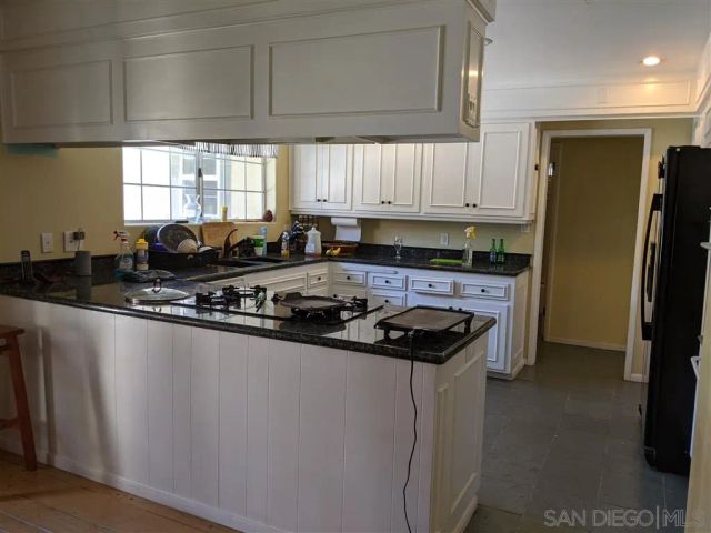 a kitchen with stainless steel appliances a sink a stove a refrigerator a window