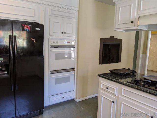 a kitchen with stainless steel appliances granite countertop a refrigerator and a stove