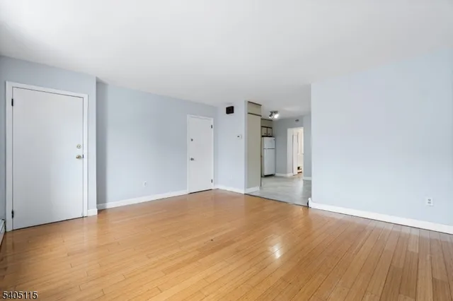 a view of an empty room and wooden floor