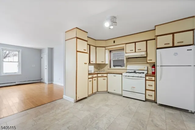 a kitchen with white cabinets and white appliances