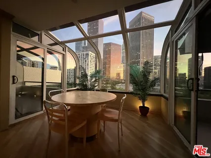 a dining room with furniture and a floor to ceiling window