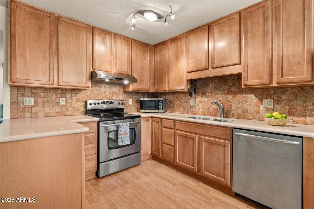 5525 East Thomas Road, Unit O12 Phoenix, AZ 85018 - Photo 5 of 27 a kitchen with granite countertop wooden cabinets and white appliances