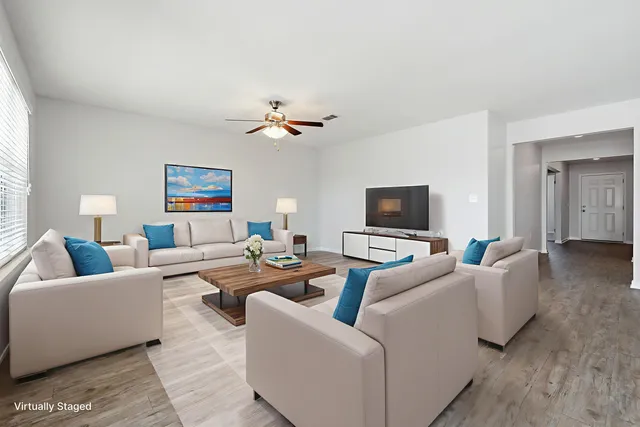 an empty room with windows and fan