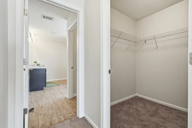 an empty room with closet and a ceiling fan