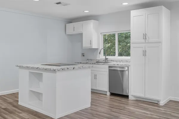 a kitchen with a sink cabinets stainless steel appliances and a window