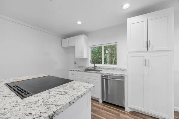 a kitchen with stainless steel appliances granite countertop a stove a sink and a refrigerator