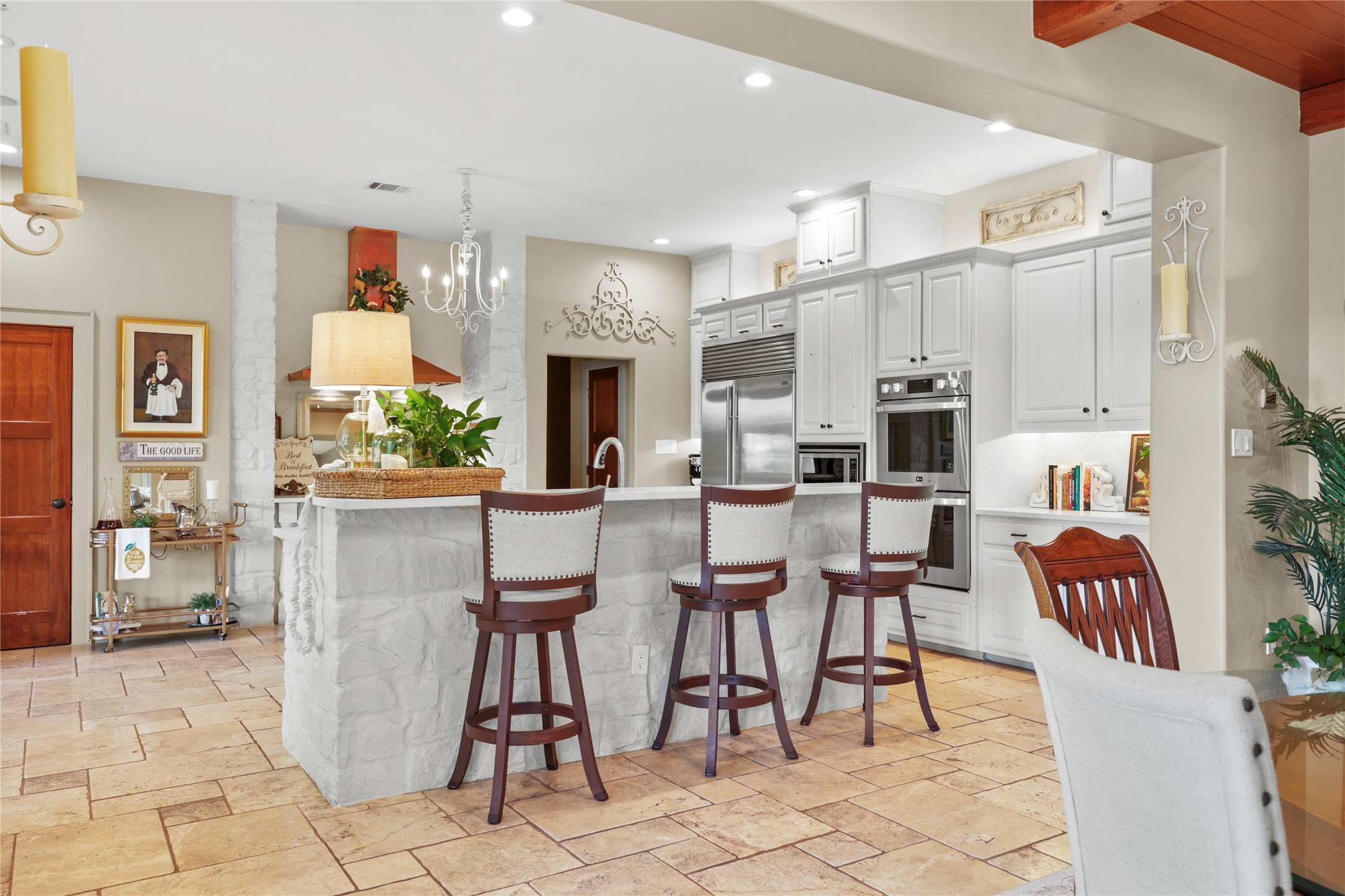 17501 Navigation Lane Lago Vista, TX 78645 - Photo 13 of 40 The kitchen features white cabinetry, stainless steel appliances, and a central island with bar seating