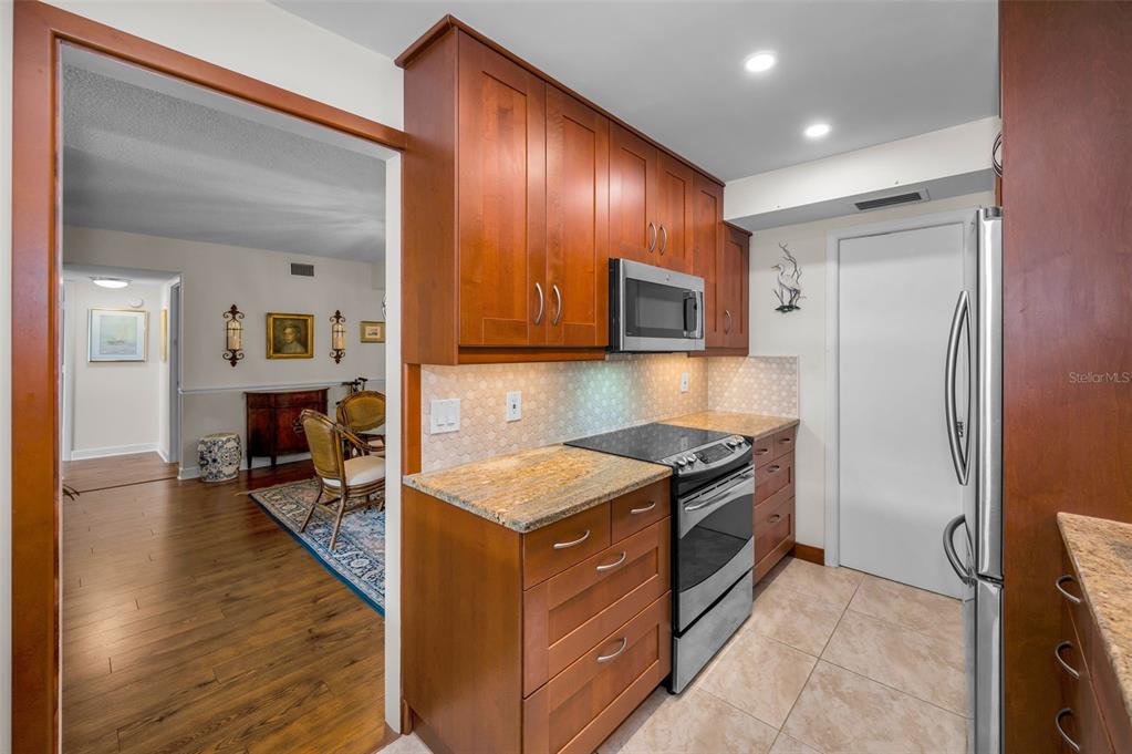 632 Edgewater Drive, Unit 433 Dunedin, FL 34698 - Photo 20 of 42 a kitchen with stainless steel appliances granite countertop wooden cabinets a refrigerator and a stove