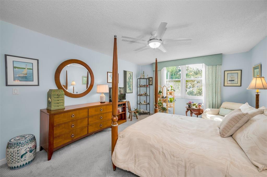 632 Edgewater Drive, Unit 433 Dunedin, FL 34698 - Photo 26 of 42 a bedroom with a bed a mirror and a large window