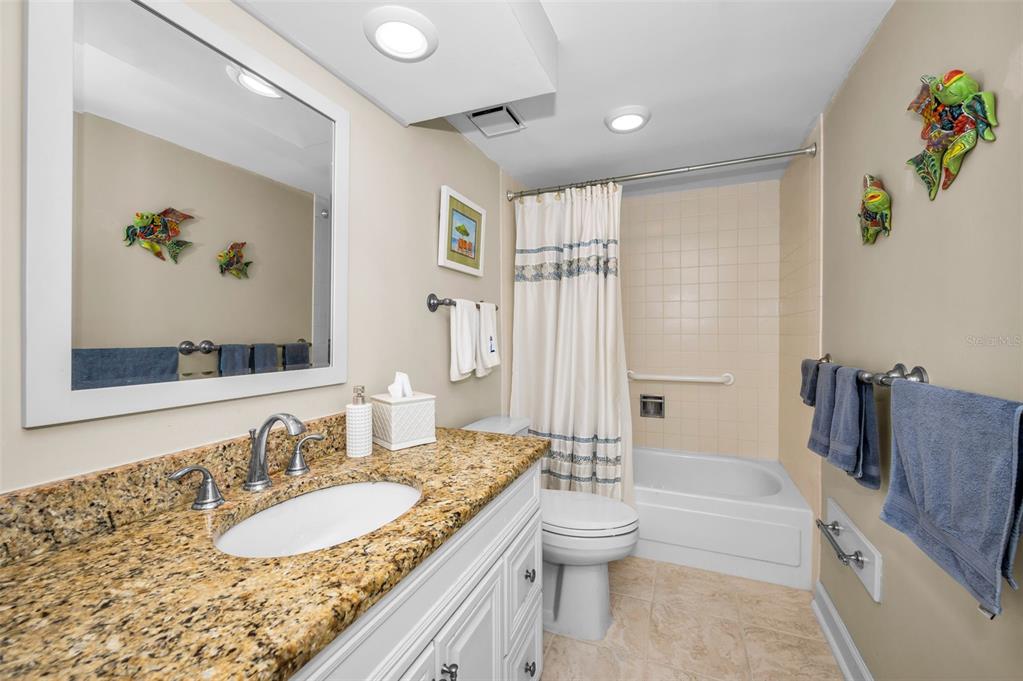 632 Edgewater Drive, Unit 433 Dunedin, FL 34698 - Photo 32 of 42 a bathroom with a granite countertop sink and a bathtub