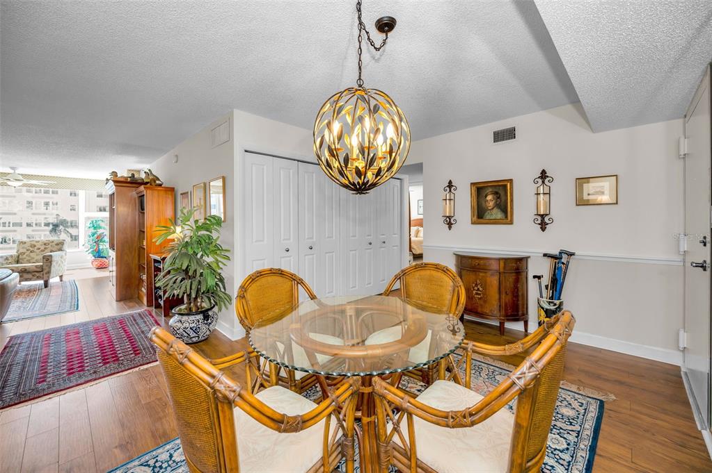 632 Edgewater Drive, Unit 433 Dunedin, FL 34698 - Photo 6 of 42 a dining room filled chandelier and wooden floor