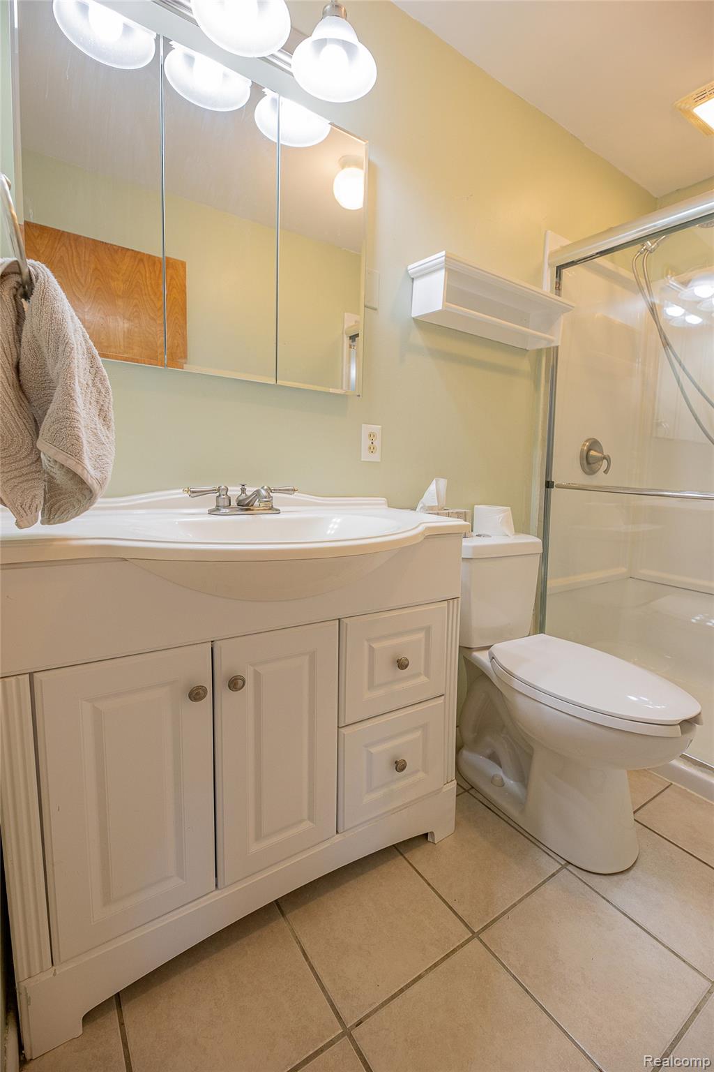 2855 Farmers Creek Road Metamora, MI 48455 - Photo 38 of 51 Bathroom featuring a white vanity with integrated sink, chrome faucet, and a wall-mounted medicine cabinet with integrated lighting
