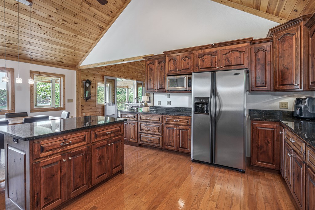 509 Lonesome Pine Road Murphy, NC 28906 - Photo 15 of 70 a kitchen with stainless steel appliances granite countertop a refrigerator a sink dishwasher a stove with wooden cabinets and floor