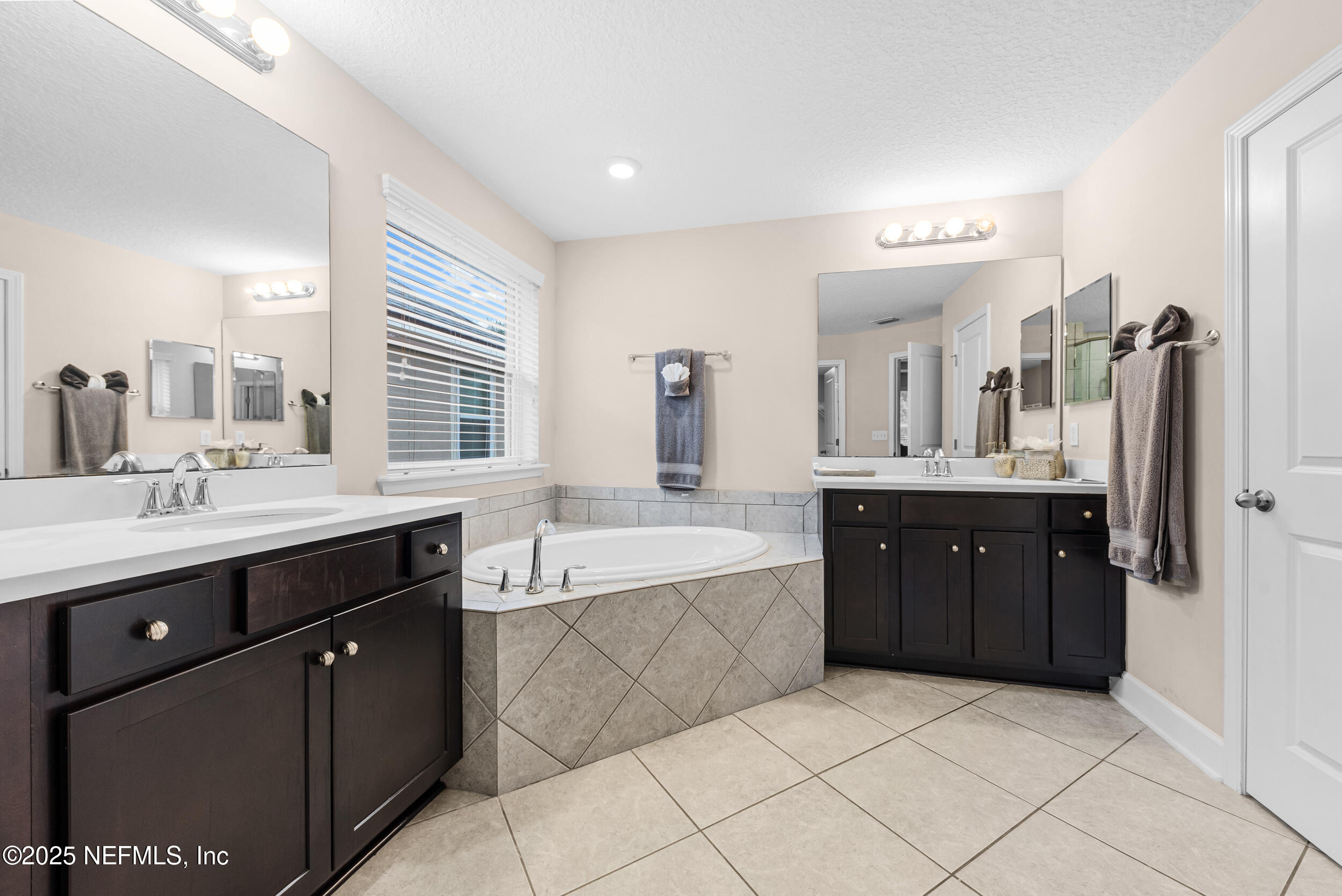 15672 Tisons Bluff Road Jacksonville, FL 32218 - Photo 14 of 42 a spacious bathroom with a granite countertop double vanity sink a mirror and a bathtub
