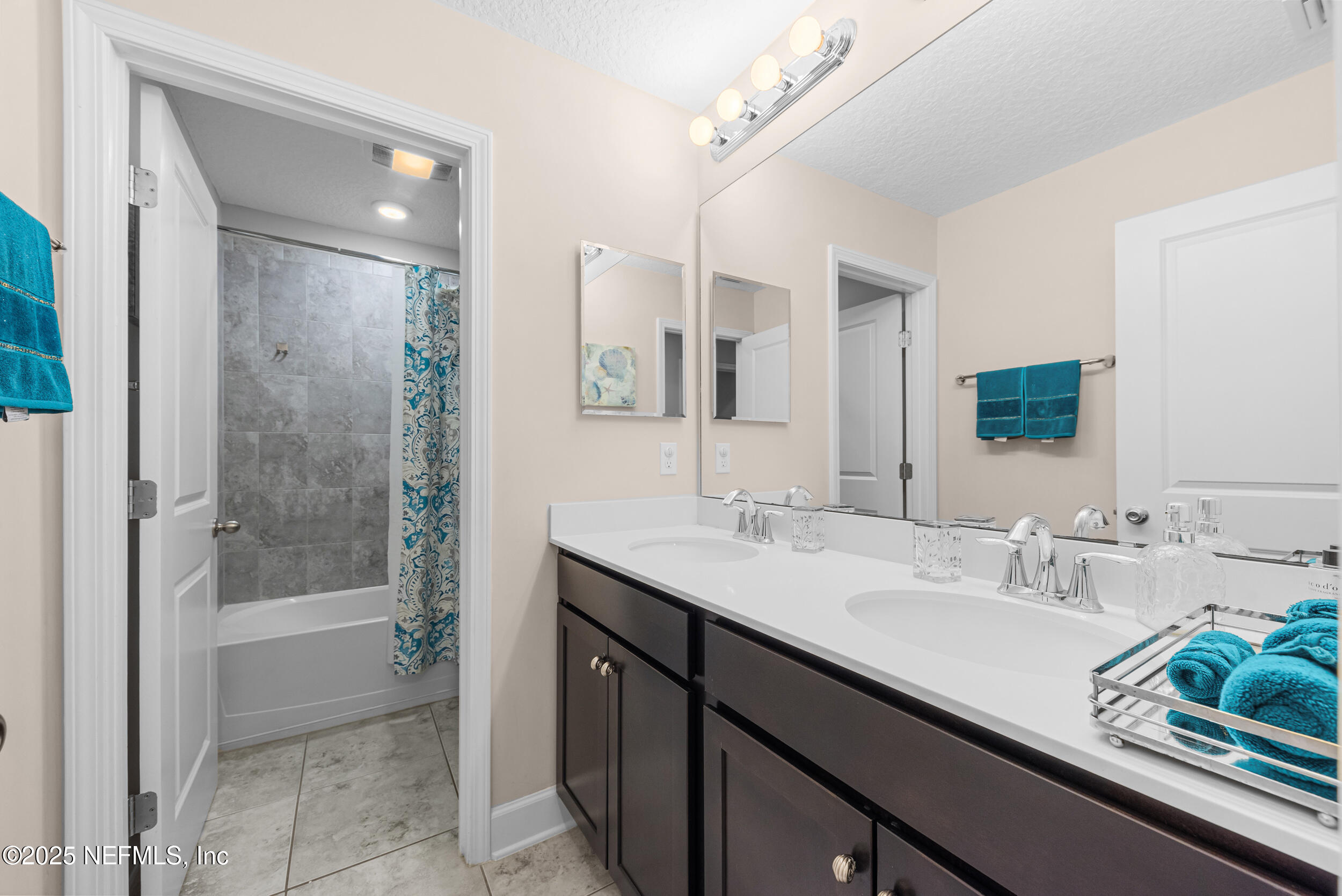 15672 Tisons Bluff Road Jacksonville, FL 32218 - Photo 21 of 42 a bathroom with a sink a large mirror and shower
