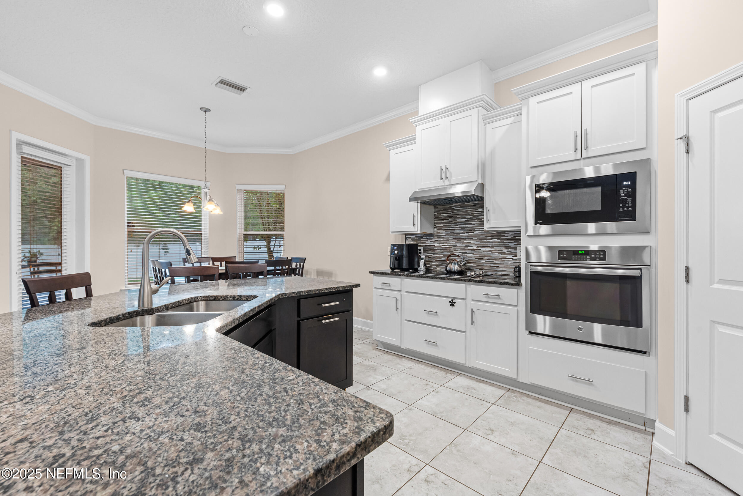 15672 Tisons Bluff Road Jacksonville, FL 32218 - Photo 26 of 42 a kitchen with a stove a sink a microwave and cabinets