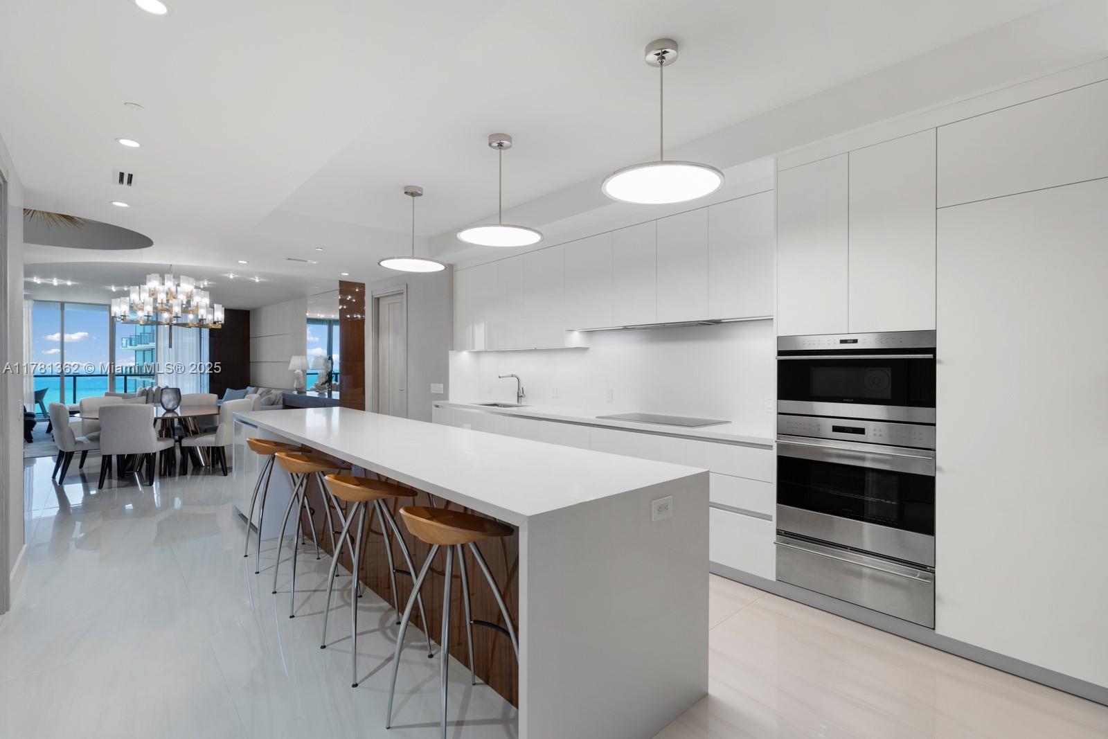 9705 Collins Avenue, Unit 2604N Bal Harbour, FL 33154 - Photo 12 of 42 a kitchen with a table chairs a sink and a stove