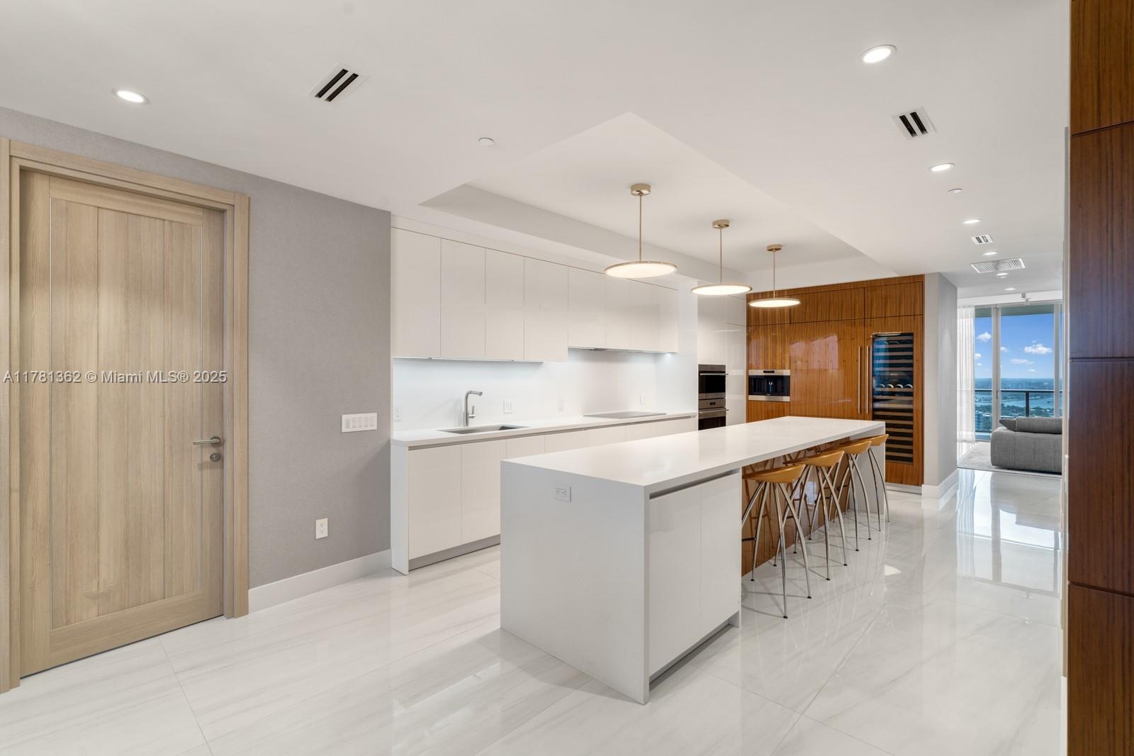 9705 Collins Avenue, Unit 2604N Bal Harbour, FL 33154 - Photo 14 of 42 a kitchen with kitchen island a sink a stove a refrigerator and chairs