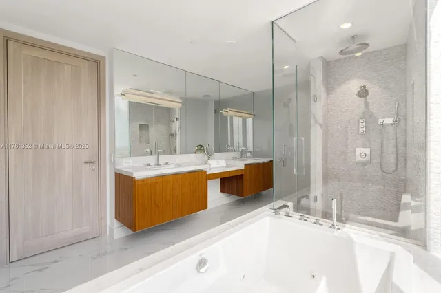 a bathroom with a tub sink shower and mirror