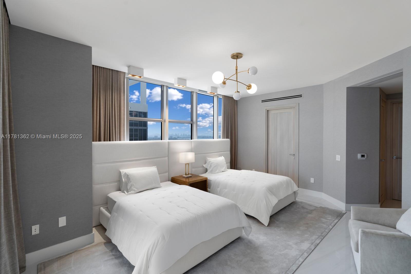 9705 Collins Avenue, Unit 2604N Bal Harbour, FL 33154 - Photo 29 of 42 a bedroom with two beds and a chandelier