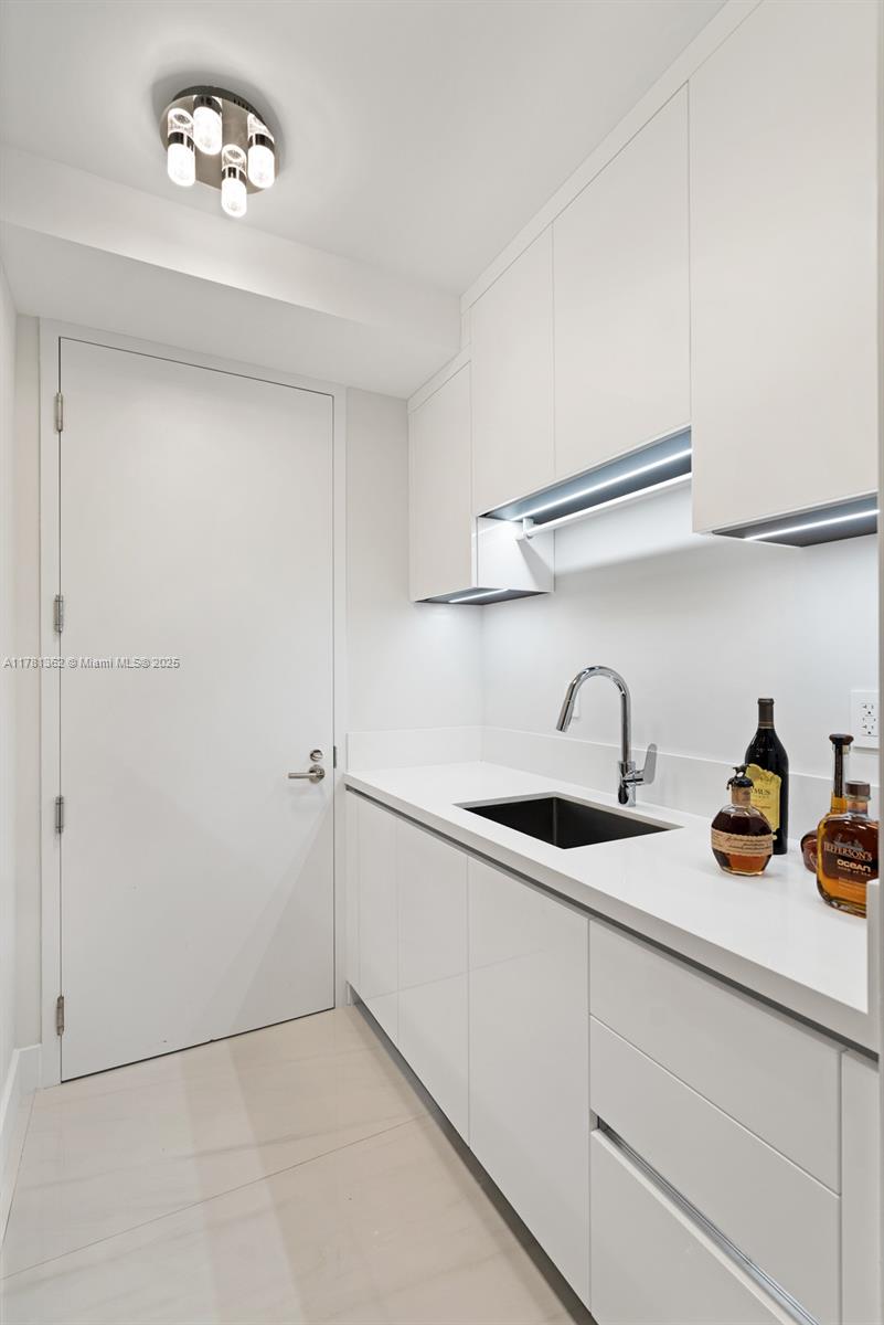 9705 Collins Avenue, Unit 2604N Bal Harbour, FL 33154 - Photo 33 of 42 a kitchen with a sink and cabinets