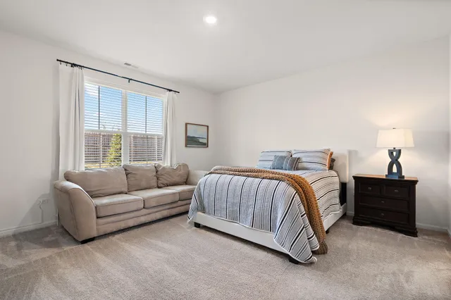 a spacious bedroom with a bed and a window