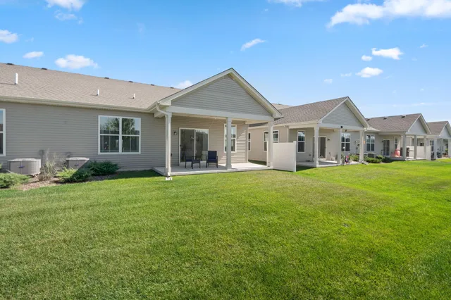 a view of a yard in front of a house with plants and large tree