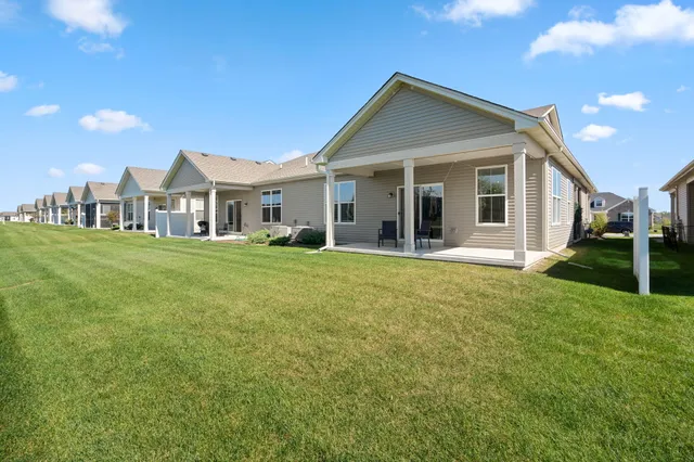 a view of a house with a yard and potted plants