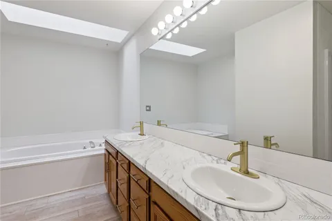 a bathroom with a granite countertop sink a toilet a mirror and vanity