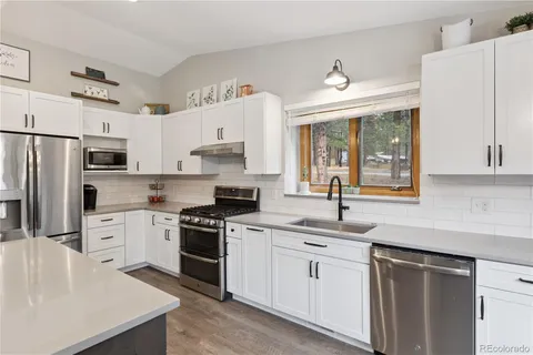 a kitchen with white cabinets and white appliances