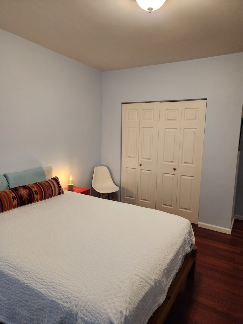 900 West Margate Terrace, Unit 2A Chicago, IL 60640 - Photo 12 of 21 a bedroom with a bed and wooden floor