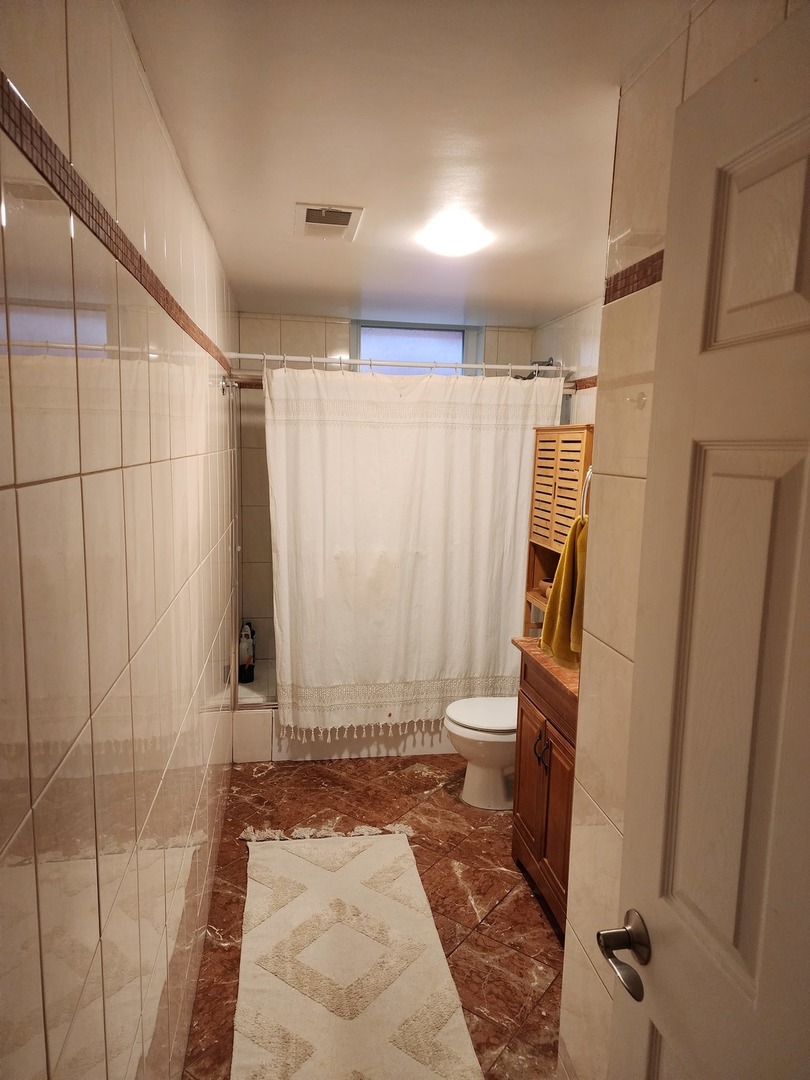900 West Margate Terrace, Unit 2A Chicago, IL 60640 - Photo 13 of 21 a bathroom with a shower and a toilet