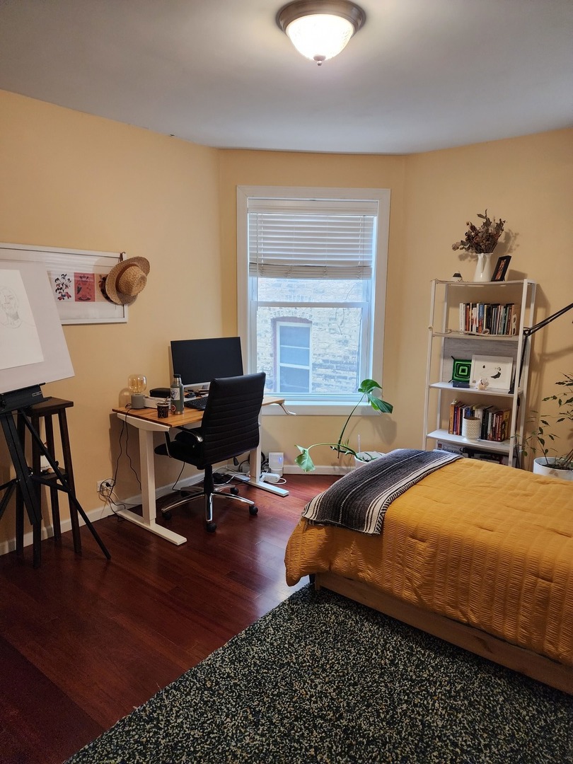 900 West Margate Terrace, Unit 2A Chicago, IL 60640 - Photo 15 of 21 a bedroom with a bed and wooden floor