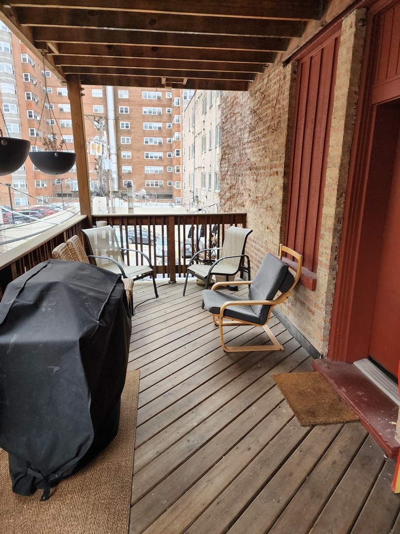 900 West Margate Terrace, Unit 2A Chicago, IL 60640 - Photo 18 of 21 a view of a balcony with chairs and wooden floor
