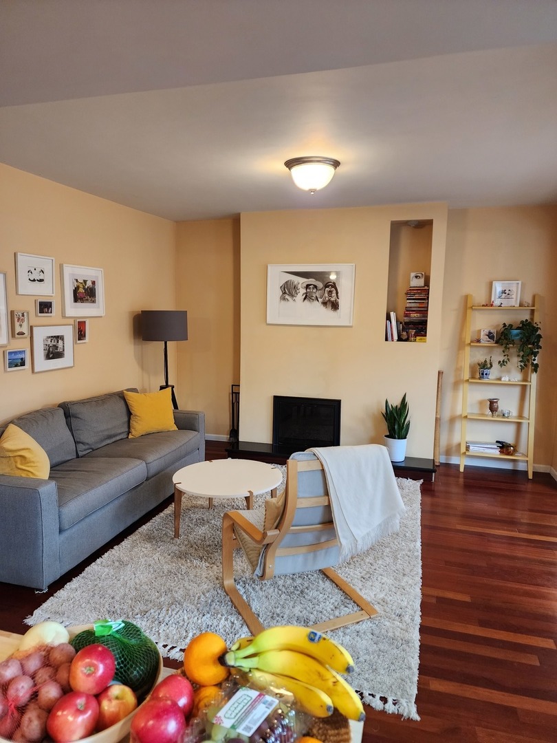 900 West Margate Terrace, Unit 2A Chicago, IL 60640 - Photo 6 of 21 a living room with furniture fireplace and wooden floor