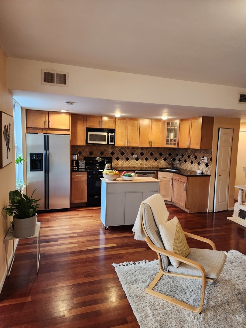 900 West Margate Terrace, Unit 2A Chicago, IL 60640 - Photo 7 of 21 a living room with stainless steel appliances furniture a rug and a kitchen view