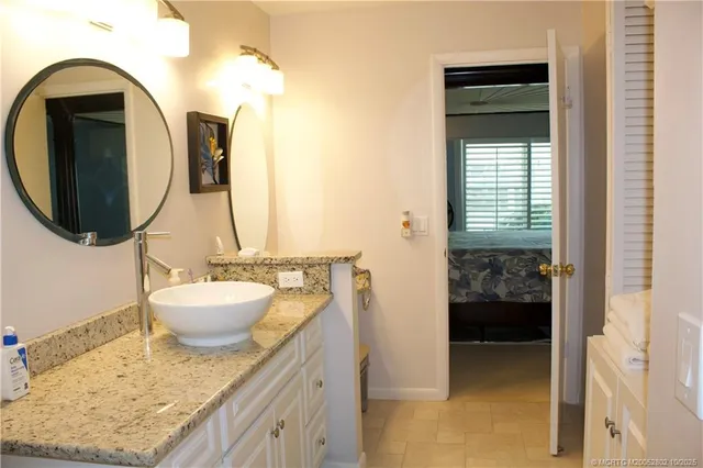 a bathroom with a granite countertop sink and a mirror
