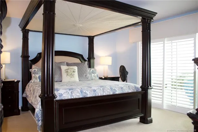 a bedroom with a bed and a large mirror next to a window