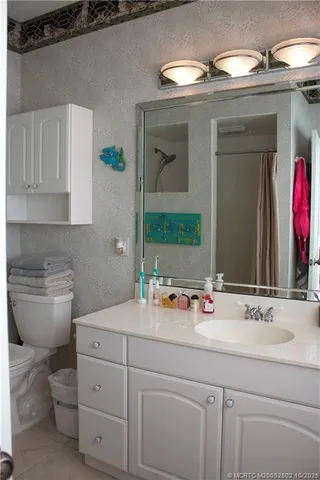 a bathroom with a toilet sink and mirror
