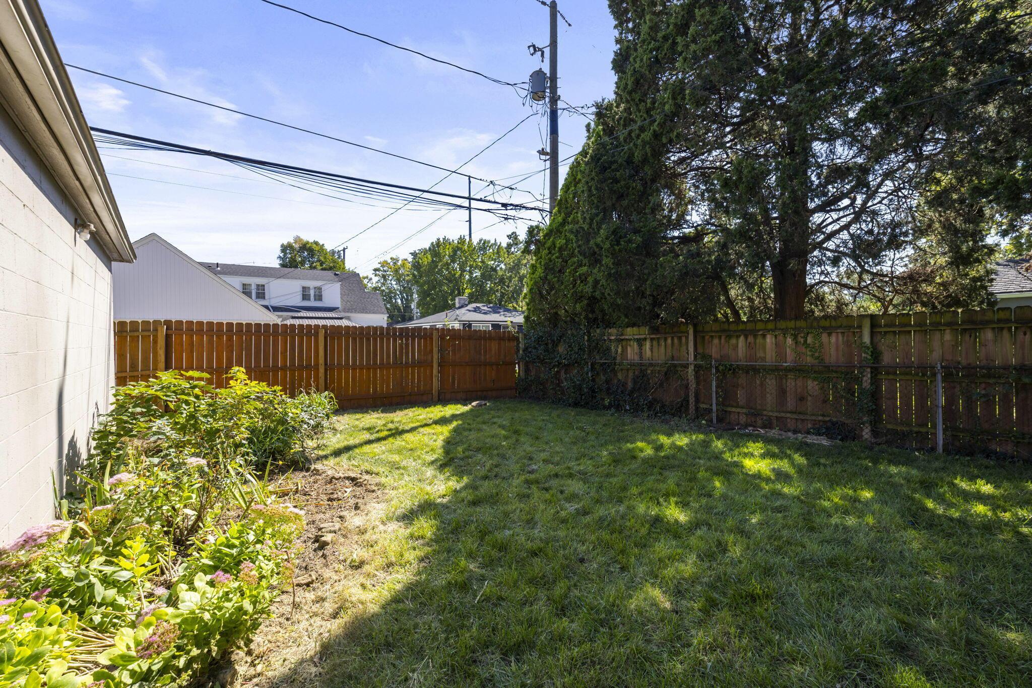 40 South Kellner Road Columbus, OH 43209 - Photo 51 of 57 Expansive rear yard featuring green lawn, established landscaping, and wood privacy fencing