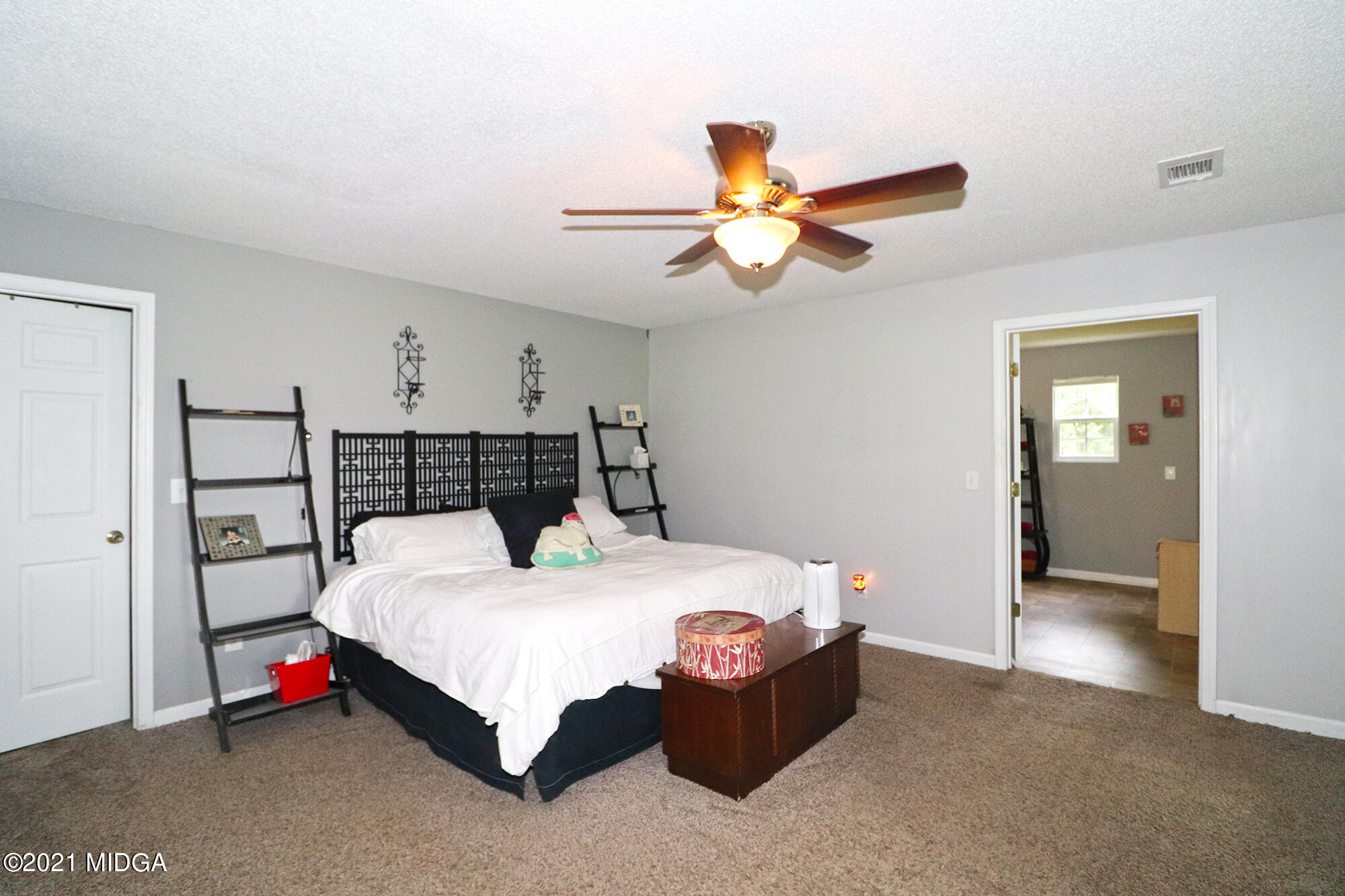 1571 Walker Road Byron, GA 31008 - Photo 23 of 60 a bedroom with a bed and a chandelier