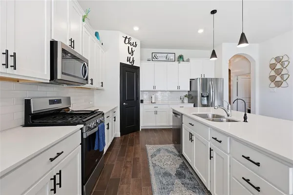 a kitchen with stainless steel appliances a stove sink and cabinets
