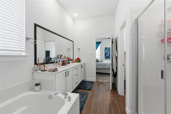 a spacious bathroom with a double vanity sink a mirror and a bathtub