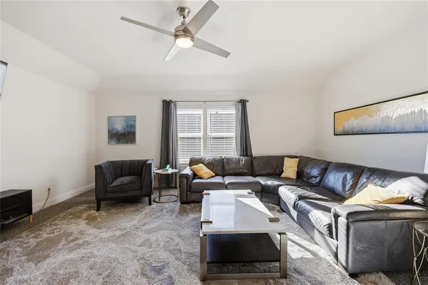 a living room with furniture a flat screen tv and a window