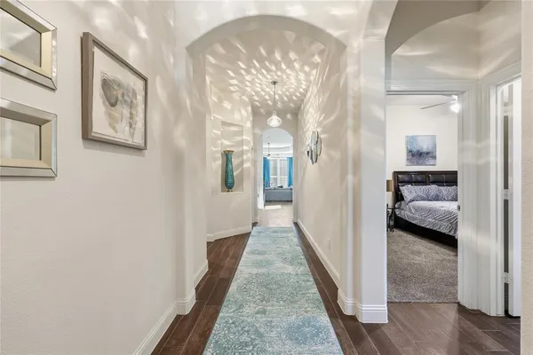 a view of a hallway with a livingroom view and windows