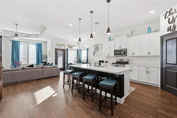 a large kitchen with kitchen island a dining table and chairs