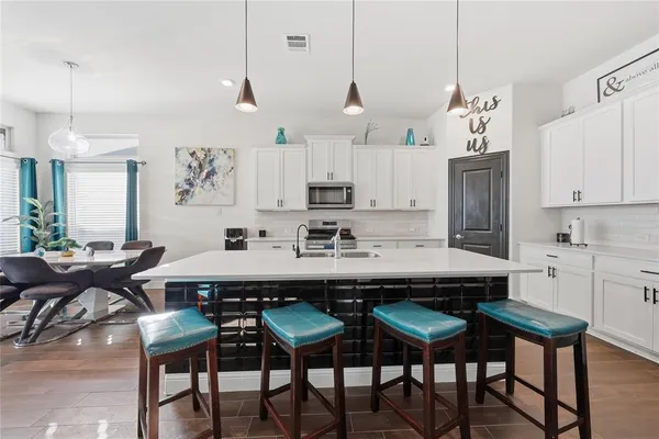 a view of kitchen with cabinets table and chairs